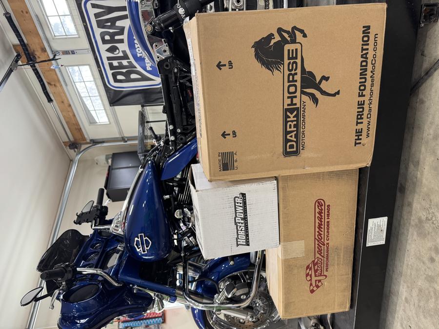 Dark Horse box along with other packages infront of customer's blue Harley